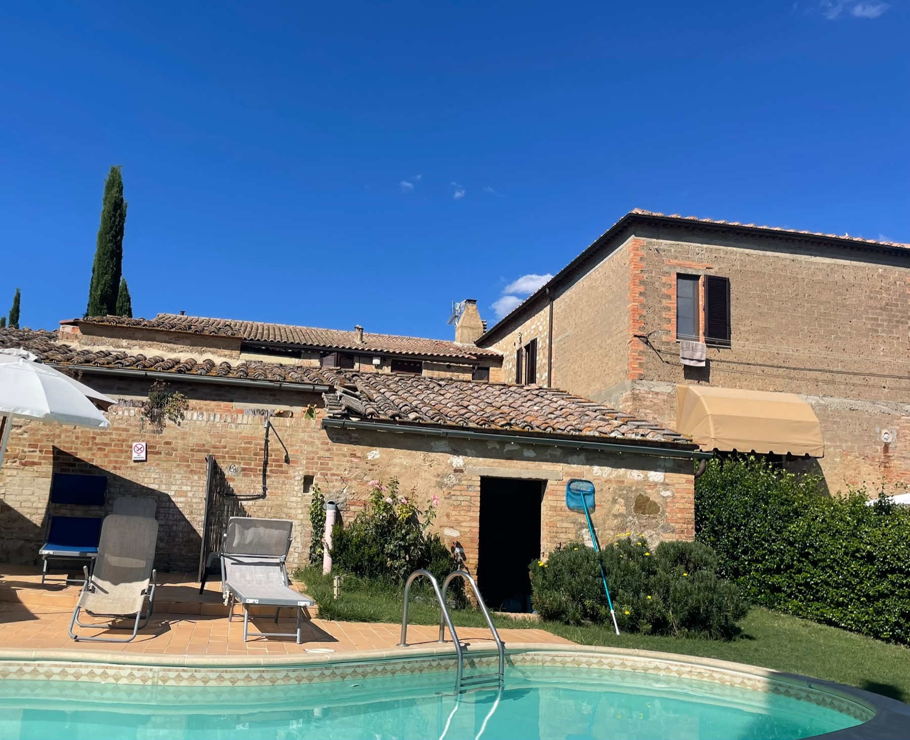 La piscina scoperta, accanto al casale in mattoni
